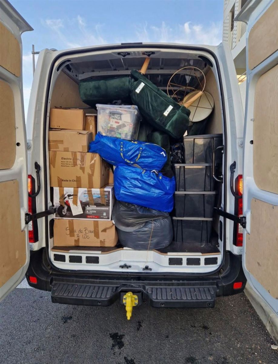 Fourgon de déménagement chargé et arrimé : cartons, bacs et meubles prêts à partir
