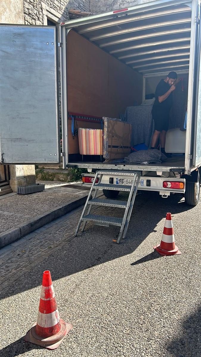Chargement d'un camion de déménagement dans le centre historique de Montpellier, zone sécurisée par cônes